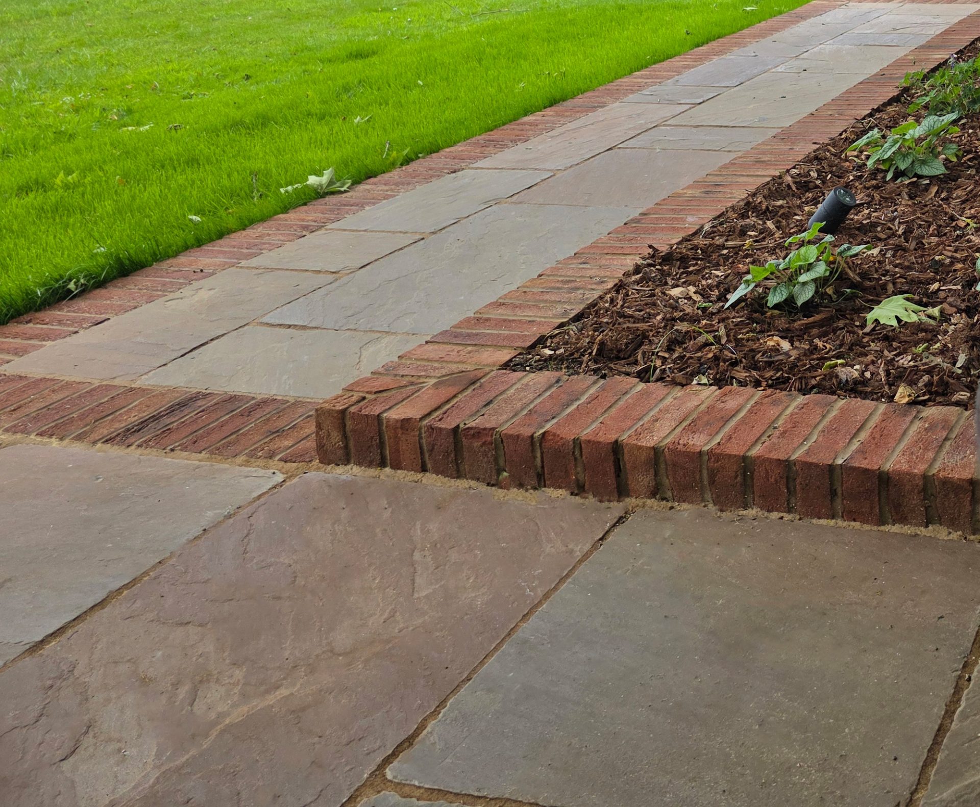 Wide view of the finished Ardley garden for the Stone Terrace & Brick Detail project.